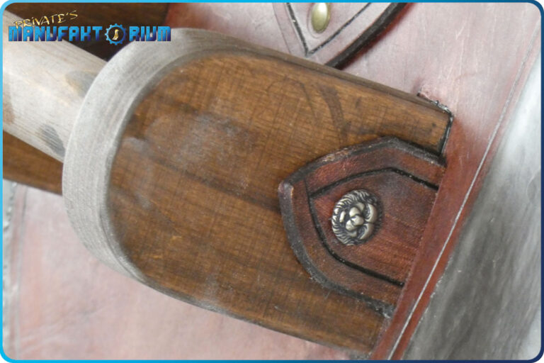 Detailbild vom LARP Schild Löwe und Greif. Der Griff ist aus echten Holz und mit Löwenkopf-Nieten an das Leder befestigt.