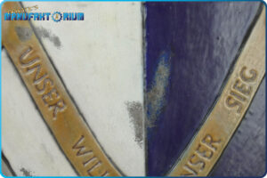 Detailansicht vom LARP Schild Löwe und Greif. Abgeplatzte Farbe, unter der metallische Farbe sich zeigt.