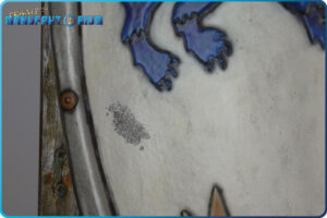 Detailansicht vom LARP Schild Löwe und Greif. Abgeplatzte Farbe, unter der metallische Farbe sich zeigt.