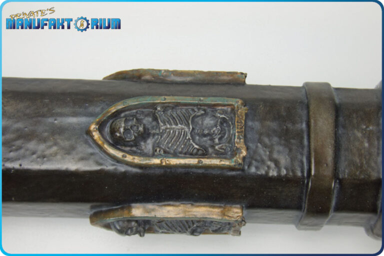 Detailansicht der Verzierung von der LARP Keule Death & Glory. Ein kleines Skelett mit goldener Umrahmung.