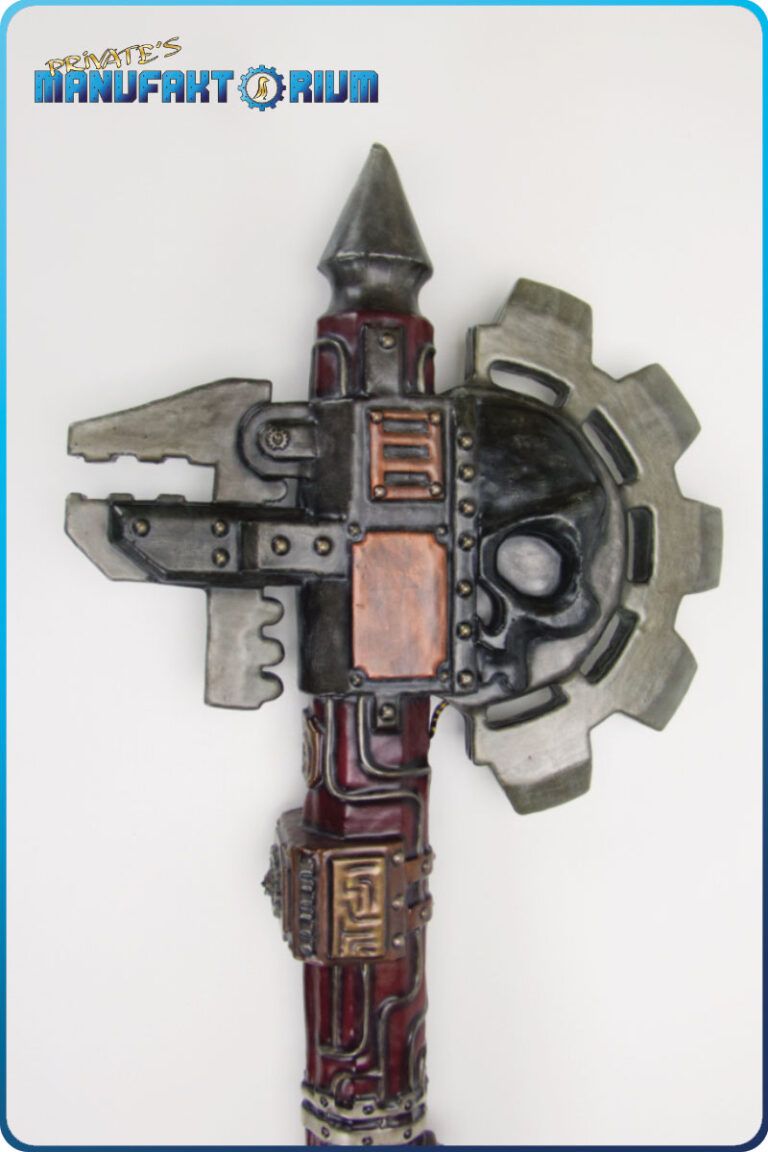 Kopfansicht der LARP Waffe Energieaxt Mk.1. Axtblatt in Zahnradform. Halber schwarzer Totenschädel. mechanische Zange.