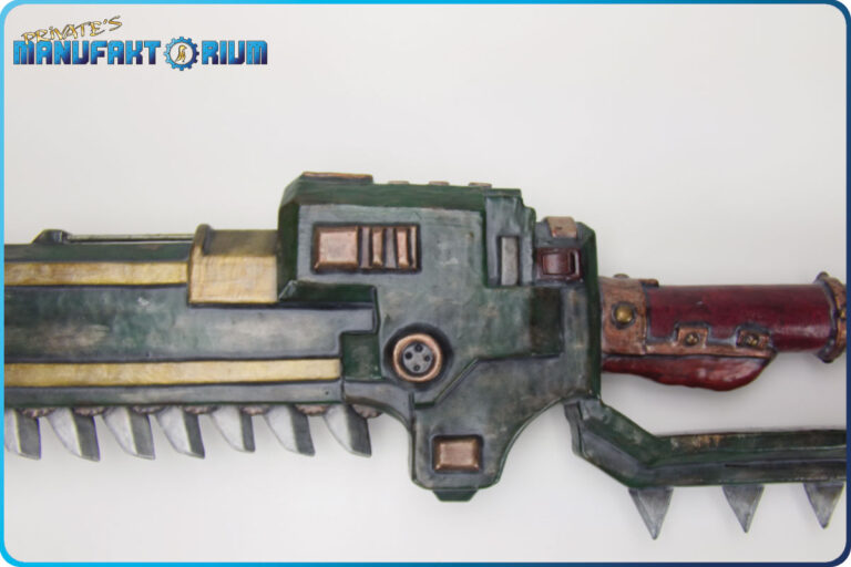 Detailansicht der LARP Waffe Kettenschwrt MK.1 Mittlerer Motorbereich von links. Grüne Grundfarbe mit abgeplatzen Stelen, goldener Verzierung.